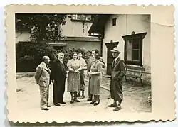 Členové slánského spolku Trhlina a jejich rodinní příslušníci před kanceláří obchodu dřevem J. Čížka. Zleva: Josef Čížek, Ludvík Kuba, Olga Čížková, Svatopluk Čížek, Neznámý, Neznámá, Jan Čížek