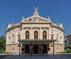 Pohled na průčelí divadelní budovy, troje velké dveře a velký krytý vchod
