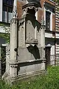 Starý Jiříkov - náhrobek rodiny Holfeldovy na bývalém hřbitově u kostela sv. Jiří, v pozadí budova radnice (1).jpg