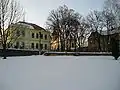 Pohled na část západní strany návsi (mateřská škola, kostel sv. Františka a bývalý křižovnický špitál)