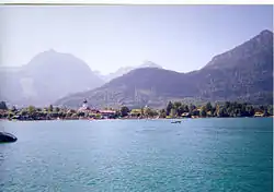 Strobl s Wolfgangsee a horami Rettenkogel (1780 m) (vlevo) a Sparber (1502 m) (vpravo) v pozadí. Menší, bližší dřevěný kopec je Hirsl, stínící vše kromě vrcholu Rinnkogelu (1823 m)