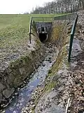 Vyústění šachty vedoucí skrz hliněnou sypanou hráz na straně za nádrží