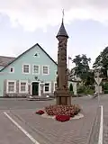 Dřevěný zastřešený sloup - památník pašerákům knih (2004) na náměstí
