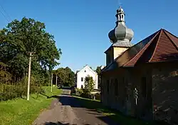 Hlavní silnice ve Svinově, vpravo kaple sv. Floriána, v pozadí stará škola