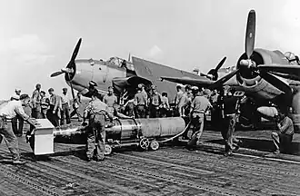 Pozdější model torpéda Mark 13 s dřevěnou ochranou hlavice a kormidel. Dřevěné konstrukce se po dopadu na vodní hladinu oddělily od torpéda. Paluba USS Wasp (CV-18) 13. října 1944.[1]