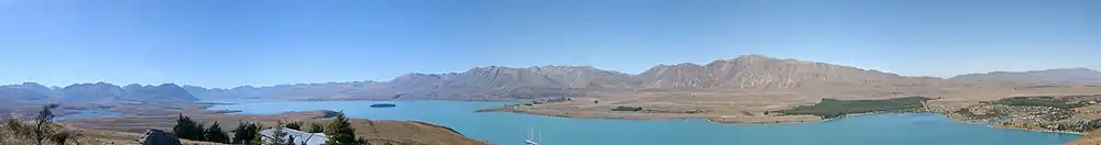 Panaroma jezera Lake Tekapo z hory Mount John, vlevo menší jezero Lake Alexandrina a napravo město Lake Tekapo