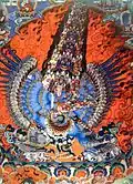 Tibetský bůh s mnoha končetinami a extravagantní mandorlou tvořenou ohněm a kouřem.