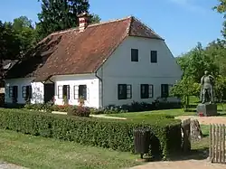Rodný dům a socha Josipa Broze Tita ve skanzenu v Kumrovci