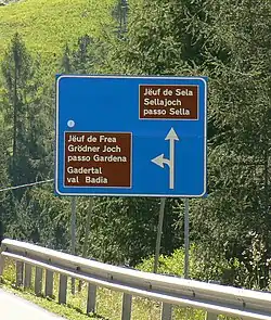 Trojjazyčná směrová tabule ve Val Gardena (ladinština, němčina, italština)