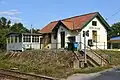 Strážní domek přestavěný na restauraci. V prosklené dřevěné části bylo ovládání závor