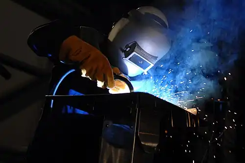 Robert Bowker welds the initials of Susan Ford Bales into the keel of the aircraft carrier Gerald R. Ford (CVN 78) during a keel laying and authentication ceremony