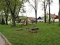 Náves s pumpou a dětským hřištěm