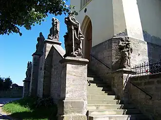 Sochy u vstupního schodiště kostela ve Všeni