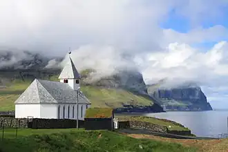 Viðareiðis kirkja s výhledem na vysoké útesy