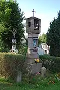 Zvonice a kříž ve vsi