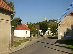 Pohled na střed obce k východu; v pozadí věž hradu Skalka