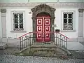 Vstupní dveře, portál, dvojice oken ohraničených pilastry (rok 2013)