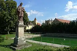 Střed obce – zleva socha sv. Jana Nepomuckého, kostel sv. Martina, obecní úřad a zřícenina zvonice, v popředí požární nádrž