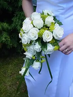 Detail na nevěstu držící v ruce kytici z bílých růží