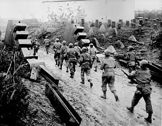 Vojáci Armády USA procházající kolem linie dračích zubů Siegfriedovy linie v roce 1944.