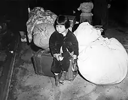 Dvouletá Juki Okinaga Hajakawa čeká na Union Station na vlak, který ji a její matku odveze do Manzanaru (duben 1942)