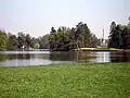 Zámek Lednice, romantický anglický park, v pozadí minaret a zbytky pseudorománské zříceniny (aquaviaduct)
