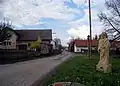 Pohled na hlavní cestu v obci se sochou svatého Floriana