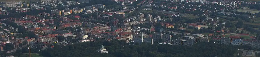 Letecký pohled na centrum Zgorzelce: na levé straně je most Jana Pavla II., dole uprostřed je bývalá Hornolužická pamětní hala s parkem Ignace Paderewského a nad ním v levé části města se nachází centrum s budovami z gründerského období s bývalými Courbièrovými kasárnami uprostřed snímku. Vpravo je sportovní palác, plovárna a sportovní hala. Nad sportovními halami lze vidět komplex někdejších Kleistových kasáren