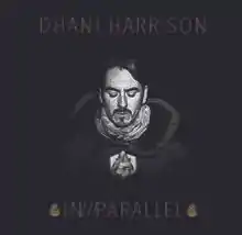 A black-haired, Caucasian man's face on a black background. All text on the cover is gold. Above his head are the words "DHANI HARRISON", and below reads "IN///PARALLEL", surrounded by what appear to be two pine cones.